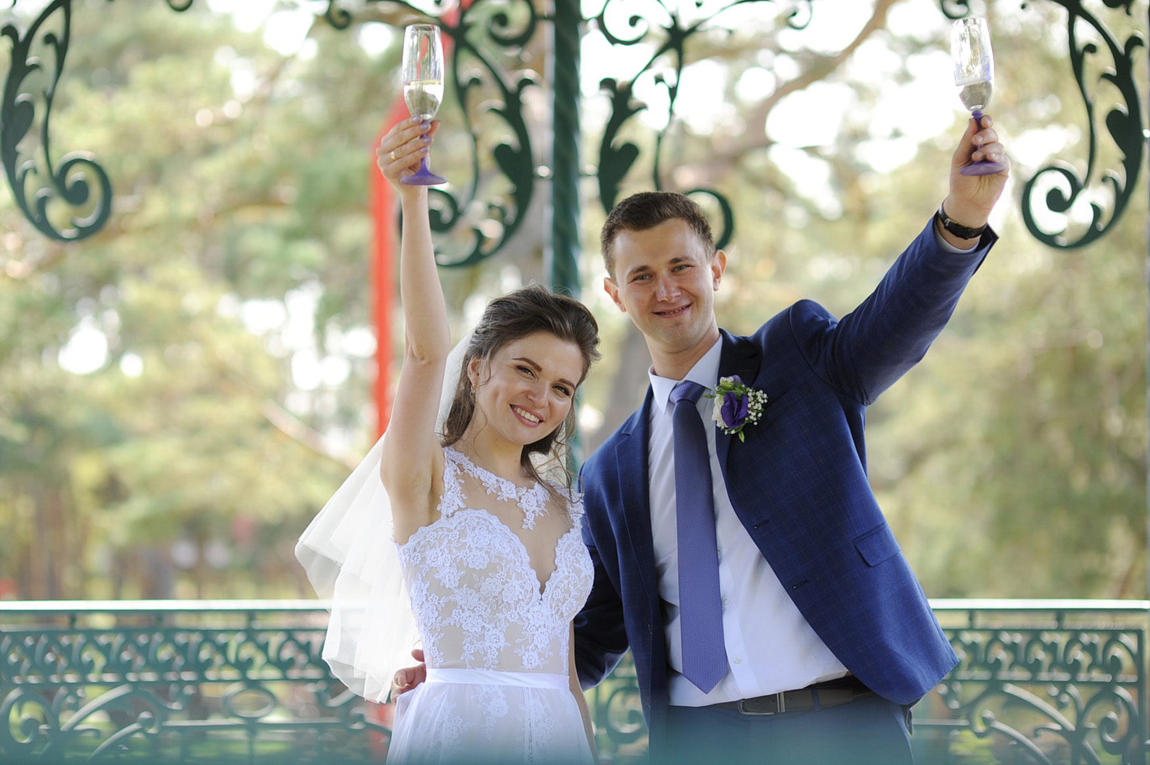 Весільний кадр з дитиною на передньому плані та парою на фоні.